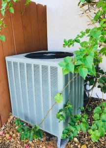 Stock photo of an air conditioning unit on the side of the house by the fence